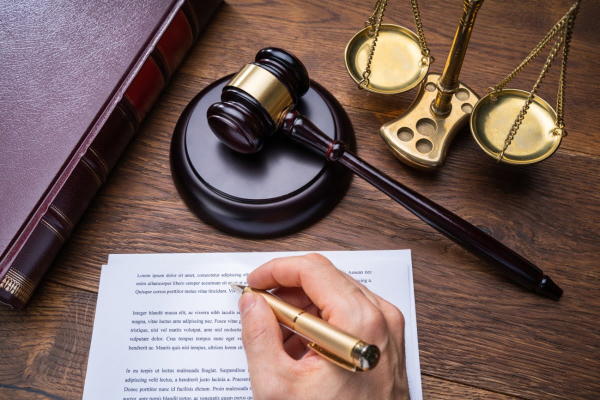 A hand drafting case briefs on a wooden table.