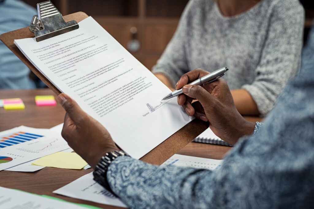 A person holding a clipboard and writing case briefs on a piece of paper.