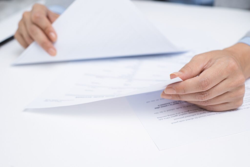 A woman's hand is holding a piece of paper containing case briefs.