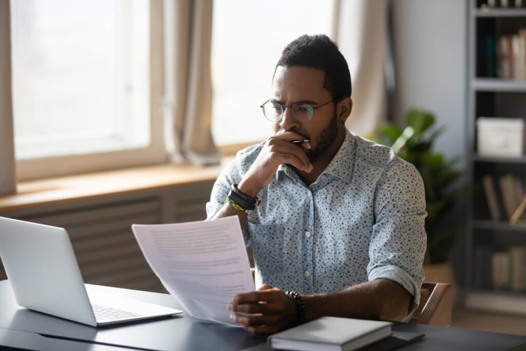 A man sitting at a desk attentively reviewing legal complaints.