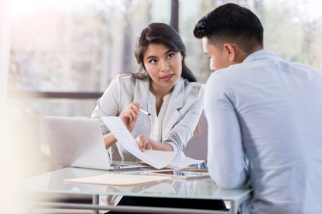 Two asian business people sitting at a table and discussing legal complaints.