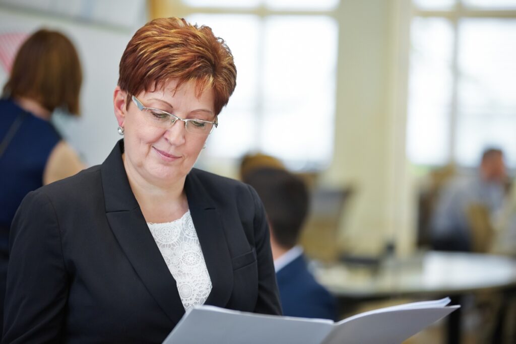 A woman in a business suit ensuring FCRA compliance while reading a document.