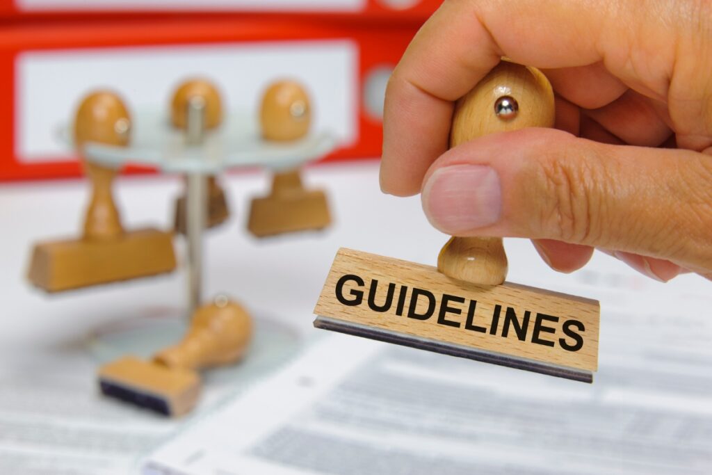 A person holding a rubber stamp with the words "FCRA compliance guidelines.